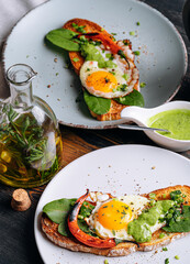 delicious and appetizing bruschetta with fried eggs and herbs for breakfast