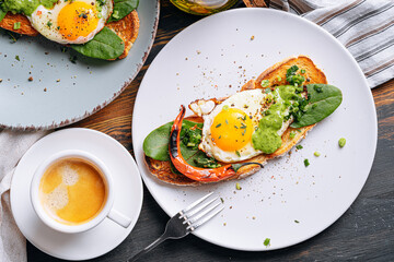 hearty and high-calorie breakfast. delicious and mouth-watering bruschetta with fried eggs and herbs for breakfast with a cup of aromatic coffee.