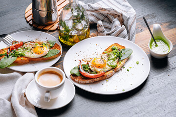 hearty and high-calorie breakfast. delicious and mouth-watering bruschetta with fried eggs and herbs for breakfast with a cup of aromatic coffee.