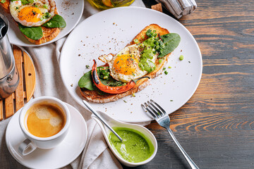 hearty and high-calorie breakfast. delicious and mouth-watering bruschetta with fried eggs and herbs for breakfast with a cup of aromatic coffee.
