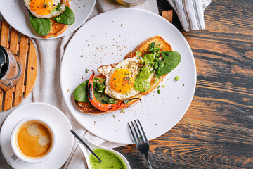 hearty and high-calorie breakfast. delicious and mouth-watering bruschetta with fried eggs and herbs for breakfast with a cup of aromatic coffee.