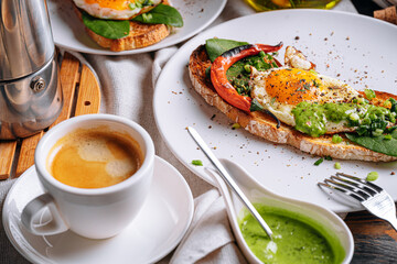 hearty and high-calorie breakfast. delicious and mouth-watering bruschetta with fried eggs and herbs for breakfast with a cup of aromatic coffee.
