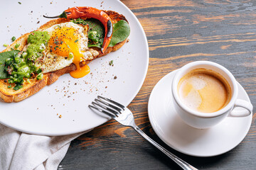 hearty and high-calorie breakfast. delicious and mouth-watering bruschetta with fried eggs and herbs for breakfast with a cup of aromatic coffee.