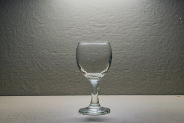 
A glass glass stands on a table under a lantern, a photo in the room
