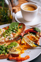 hearty and high-calorie breakfast. delicious and mouth-watering bruschetta with fried eggs and herbs for breakfast with a cup of aromatic coffee.
