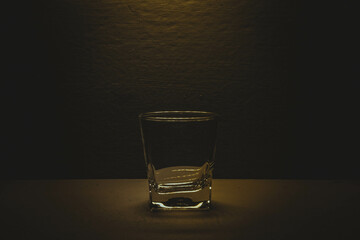 A glass glass stands on a table under a lantern, a photo in the room