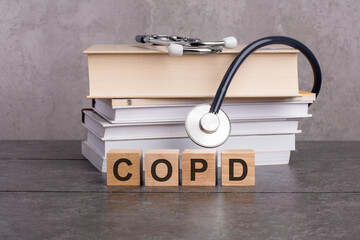 Text abbreviation on wood cubes blocks on gray background. COPD - short for Chronic Obstructive...
