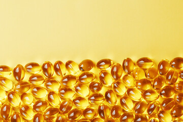 Capsules in a shell with liquid vitamin D3 on a yellow background and a place for text