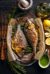 the concept of a delicious dinner for two from dorado. baked dorado fish with asparagus and lemon...