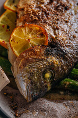 the concept of a delicious dinner for two from dorado. baked dorado fish with asparagus and lemon in spices