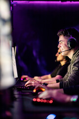 Fototapeta na wymiar A smiling gamer playing online video games at gaming room.
