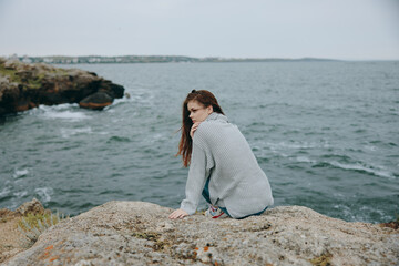 Naklejka na ściany i meble portrait of a woman seated on the coast sweater landscape unaltered
