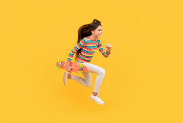 Fototapeta na wymiar happy energetic child skateboarder jumping with penny board skateboard, childhood