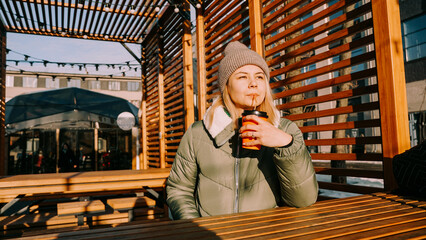 Happy woman on a winter sunny day at a street food fair in space for relaxing and meeting friends....