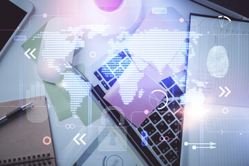 Double exposure of map hologram drawing over study table background with computer. Concept of international network. Top view.