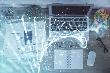 DNA hologram drawings over computer on the desktop background. Top view. Multi exposure. Concept...