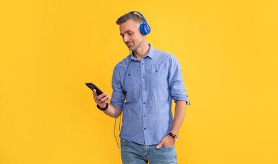 smiling mature man listen music in headphones and chat on phone, communication