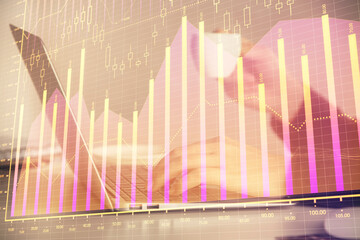 Double exposure of businesswoman hands typing on computer and forex graph hologram drawing....