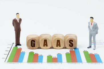 On financial reports with graphs, a figure of businessmen and wooden cubes with the inscription -...