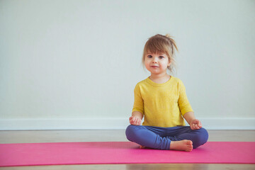 Charming baby doing yoga. Place for text