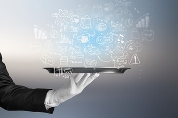 Handsome young waiter holding icons on tray