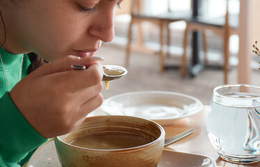 Young girl eating soup at a restaurant