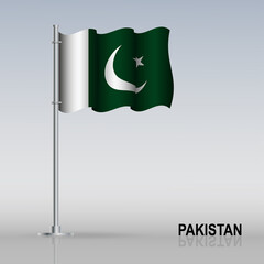 Flag of Pakistan flying on a flagpole stands on the table