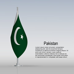 Flag of Pakistan hanging on a flagpole stands on the table