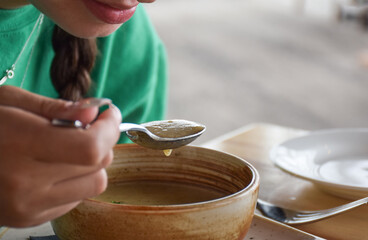 Fototapeta na wymiar Young girl eating soup at a restaurant