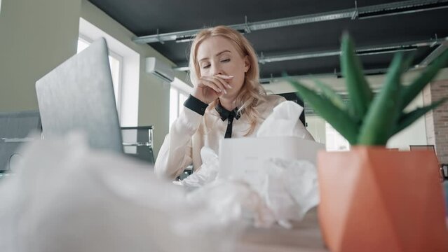 sick manager sitting at workplace using napkin seasonal allergies ill woman in the office