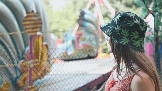 A girl looks at a working ride in a children's park.