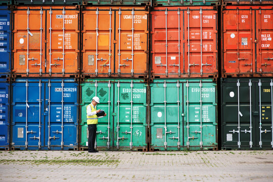 Concentration and hard work is key. A customs inspector standing and reviewing a tack of containers.