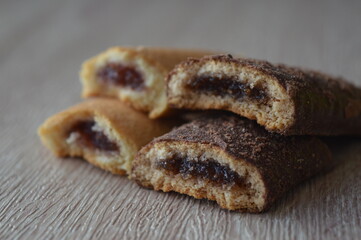 homemade mini strudels stuffed with cherry jam on a wooden background