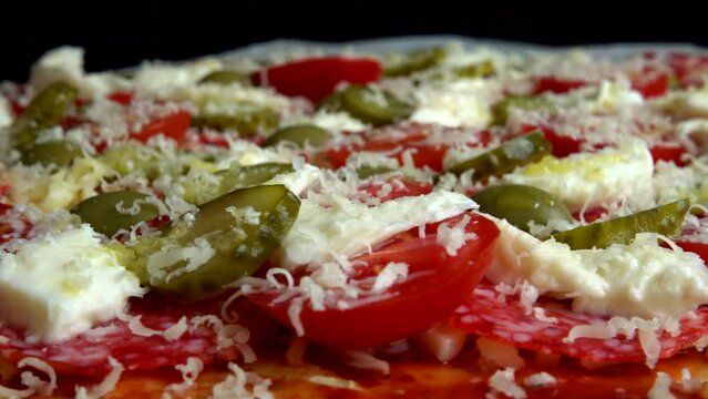 Spinning pizza with mozzarella cheese, olives, pickled