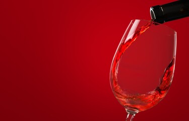 Red wine glass over colored background on the desk