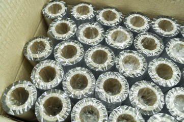 Packed thermal transfer ribbon in cardboard box. TTR. Wax thermo ribbon on cardboard reel for barcode. Supply material for printing industry. Selective focus