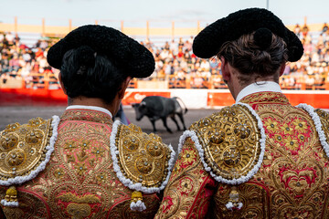 bullfighter on his back looking at the bull