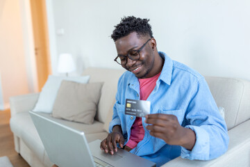 Online payment,Young Man holding credit card and computer laptop for online shopping. black friday or cyber monday concept. Man paying with credit card on laptop at home office
