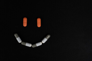 Pills forming a happy smile. Orange and white pills.