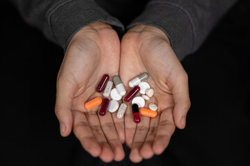 Two hands holding pills. Medicine for depression, fever, stomach pain.