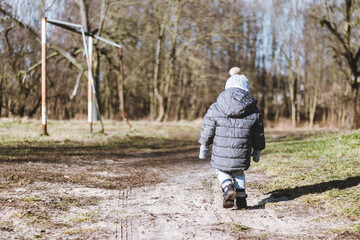 Samotny chłopiec spacerujący w parku. - obrazy, fototapety, plakaty