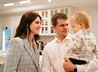 Fototapeta premium a beautiful dark-haired woman and man with a one-year-old boy at the banquet. 