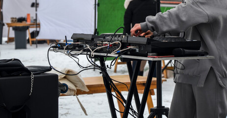 Close up on hands of dj mixing music, tweaking various track controls on sound board. Entertainment and fest concept. Selective focus