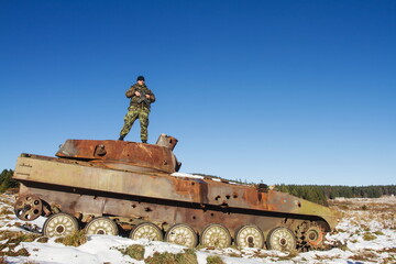 Fototapeta na wymiar infantry combat vehicle an old shot-up infantry combat vehicle with an armed patrol standing on top