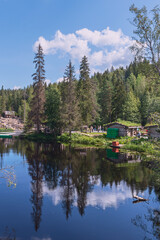 blue forest lake with small wooden houses for tourists on the shore. Karelia. Russia