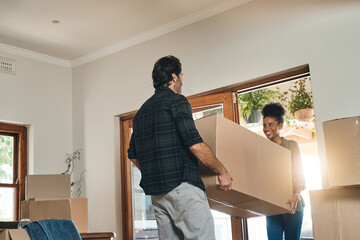 I cant wait to raise our little ones here. Cropped shot of an affectionate young couple assisting each other to carry a box into their new home. - obrazy, fototapety, plakaty