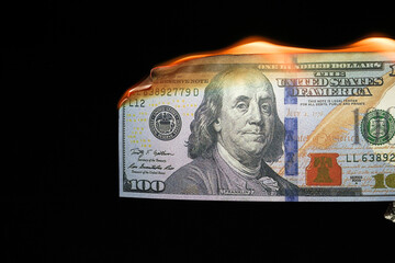 Close up shot of a 100 dollar banknote burning