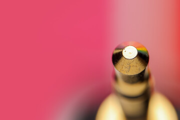 Extreme close up shot tip end of the aux jack on pink background