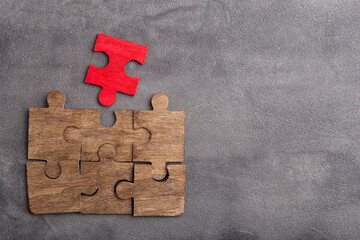 Creative idea and solve the problem concept. Teamwork success strategy - wooden puzzle on the grey...