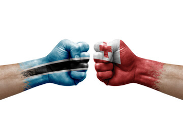 Two hands punch to each others on white background. Country flags painted fists, conflict crisis concept between botswana and tonga